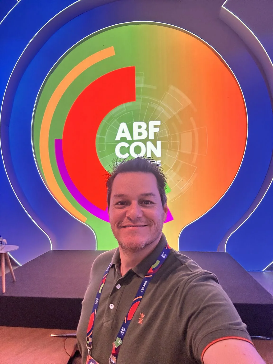 Alexandre Passarelli diante da identidade visual da ABF CON 2025